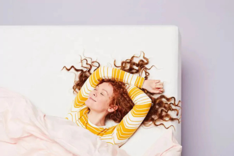 Woman lying comfortably on hybrid mattress for sleep tips and benefits guide