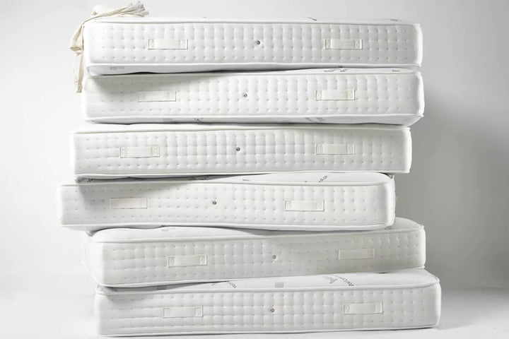 Stack of mattresses for bed and mattress buying guide