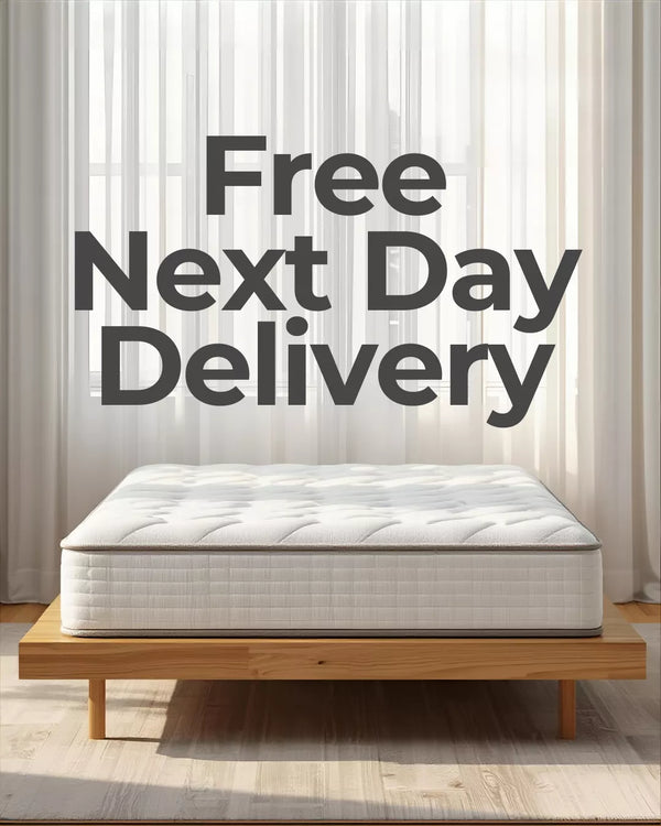 Mattress on a wooden bed frame with 'Free Next Day Delivery' text in a room.